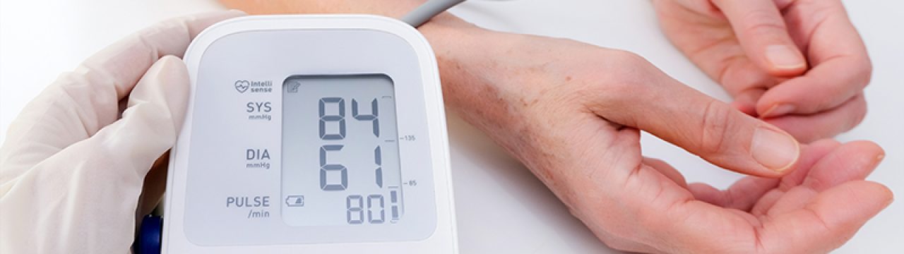doctor in gloves measures blood pressure to a person, white background. arterial hypotension. hand and tonometer close up.