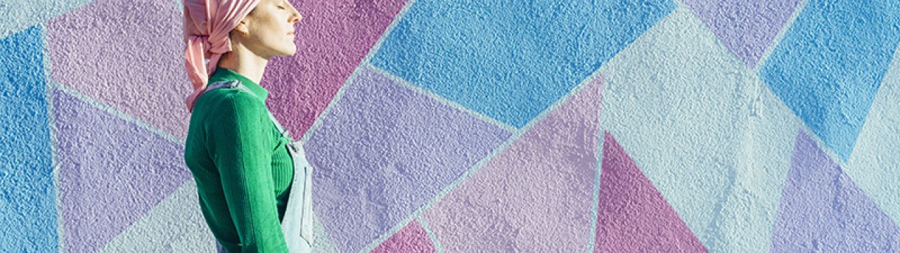Woman with headscarf fighting cancer on a colorful wall