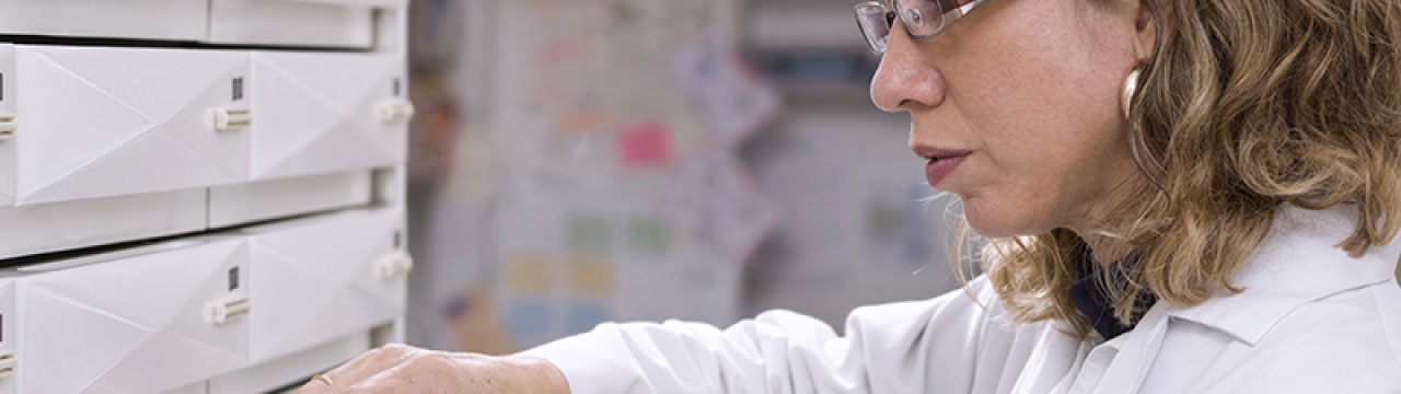 Cropped view of pharmacist taking medicine from drawer
